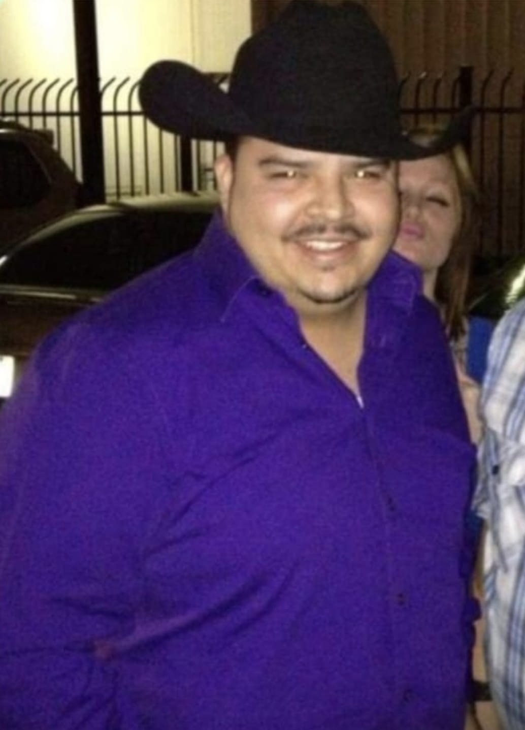 The founder before his transformation, wearing a purple shirt and black cowboy hat